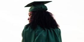 a behind shot of a woman in a graduation cap and gown
